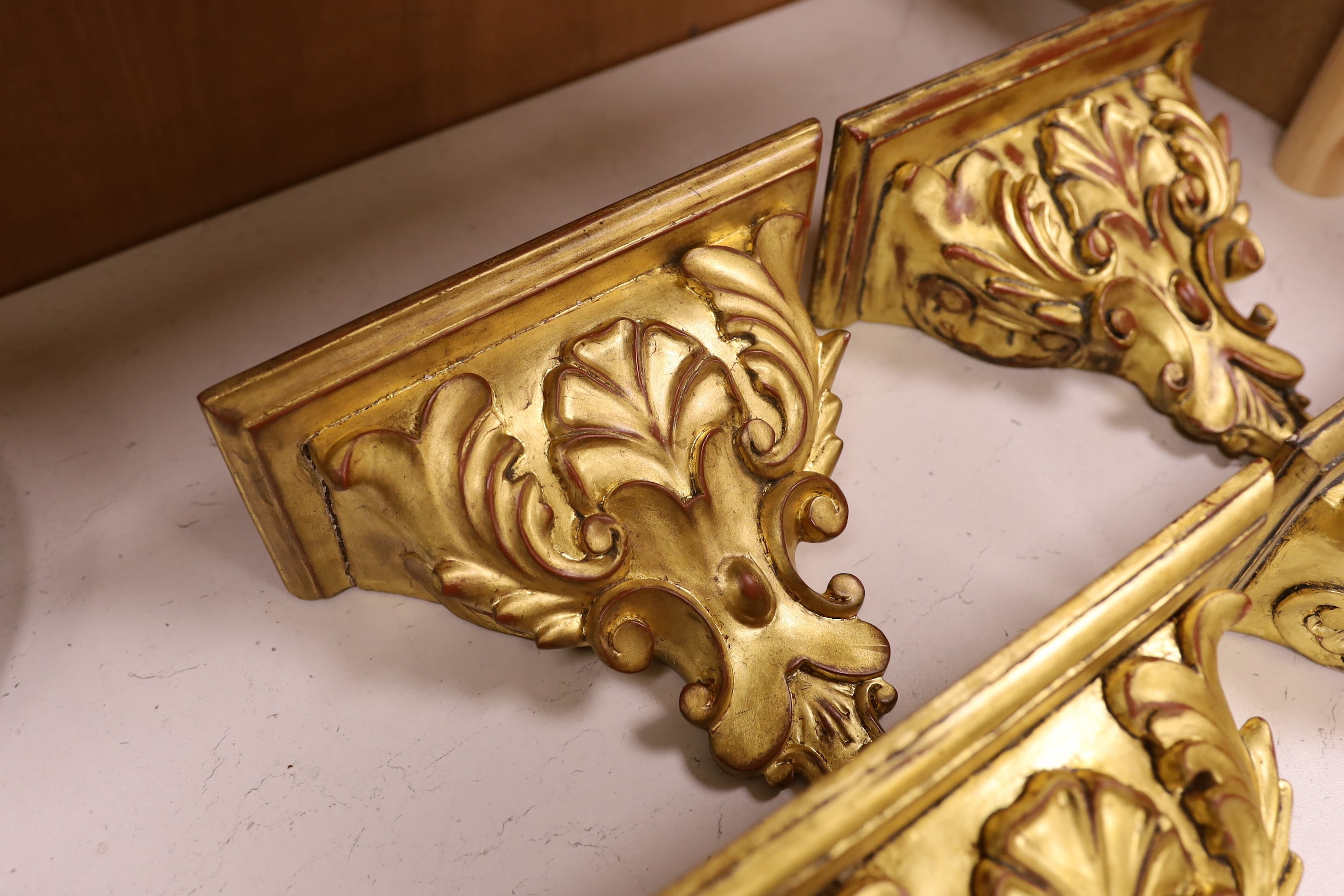 A set of four gilt wood wall brackets, 18.5cm tall x 24cm wide